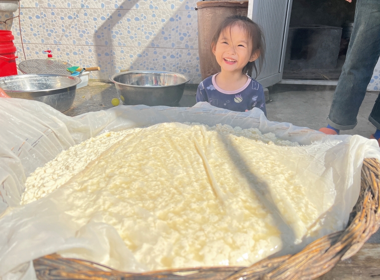 小外甥女帮母亲拉着豆腐包，白嫩嫩的豆腐脑马上就要变成卤水豆腐了